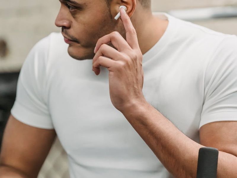 A focused man in athletic wear during a moment of pause in his workout.